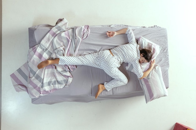 Retrato de vista superior de uma jovem de pijama dormindo na cama conceito de cochilo de relaxamento de conforto