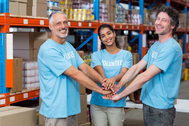 Retrato de voluntários felizes, juntando as mãos