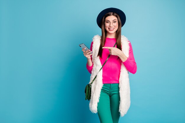 Retrato dela bonita, atraente, alegre, alegre, menina, usando um dispositivo de aplicativo 5, recomendando velocidade rápida isolada em uma parede de cor azul turquesa verde brilhante brilho vívido brilhante