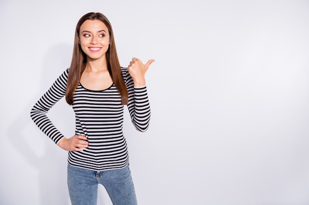 Retrato dela ela é legal atraente atraente charmosa fofa adorável muito alegre alegre conteúdo menina de cabelos lisos mostrando espaço de cópia isolado sobre a parede de luz branca