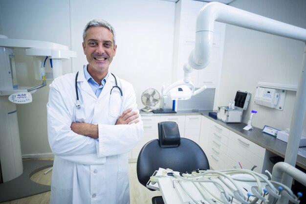 Retrato de dentista confía en pie con los brazos cruzados