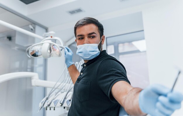 Retrato de dentista con guantes que se encuentran en el interior de la clínica.