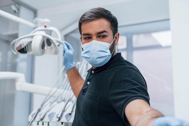 Retrato de dentista con guantes que se encuentran en el interior de la clínica.