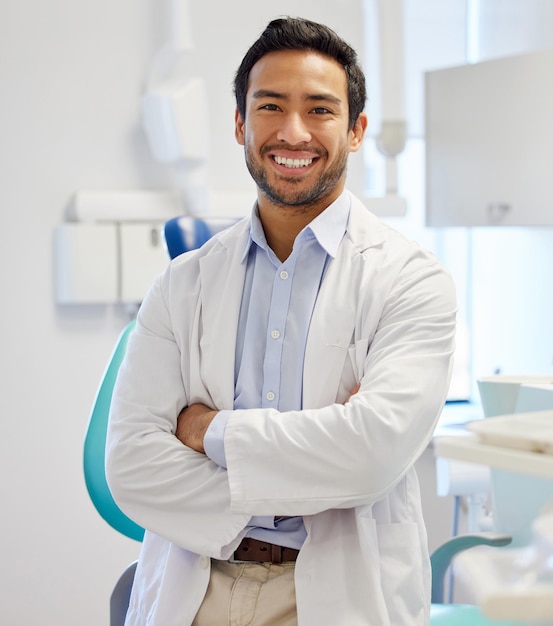 Foto retrato de dentista y hombre con los brazos cruzados para el servicio de atención médica hospital dental o seguro en la oficina de consulta persona o médico asiático feliz con dientes orales o higiene de la salud en la clínica