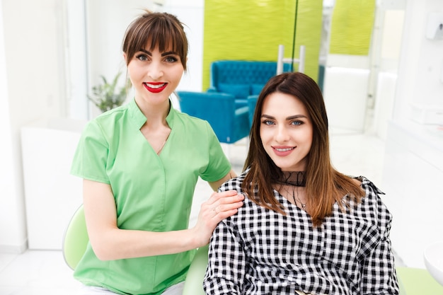 Retrato de dentista médico con hermosa mujer paciente en clínica dental