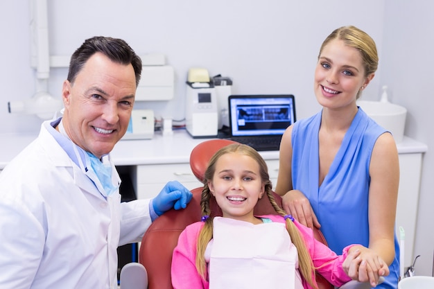 Retrato de dentista con paciente joven y su madre