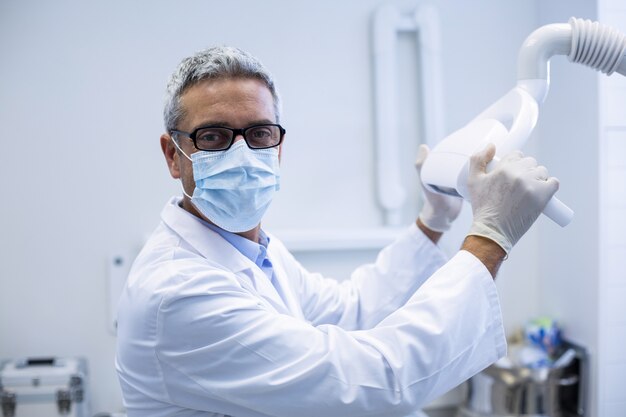 Retrato de un dentista que ajusta la luz