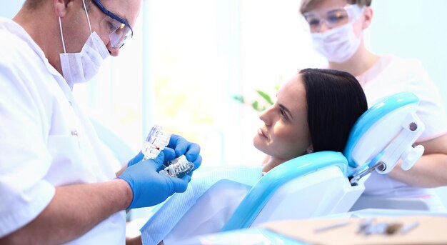 Retrato de un dentista que trata los dientes de una paciente joven