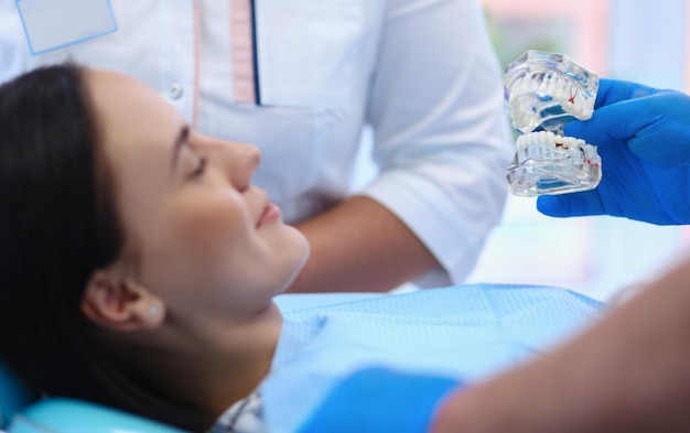 Retrato de un dentista que trata los dientes de una paciente joven