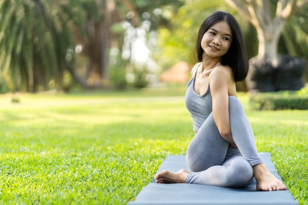 Retrato deporte asiático belleza cuerpo delgado mujer en ropa deportiva sentado relajarse y niña practicando yoga y hacer ejercicio físico en el parque en casaDieta conceptoFitness y saludable