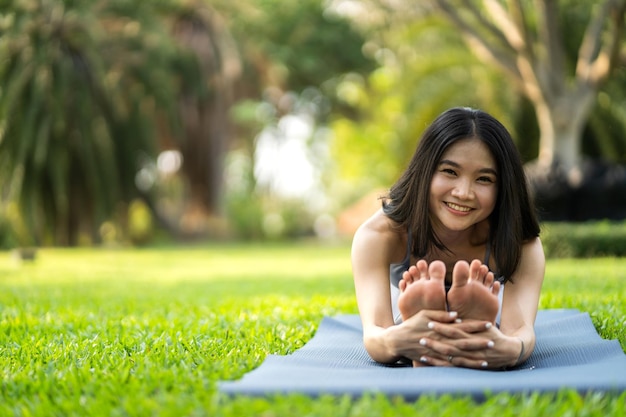 Foto retrato deporte asiático belleza cuerpo delgado mujer en ropa deportiva sentado relajarse y niña practicando yoga y hacer ejercicio físico en el parque en casadieta conceptofitness y saludable