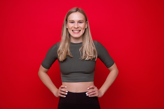 Retrato, de, un, deportivo, mujer joven, en, un, pared roja