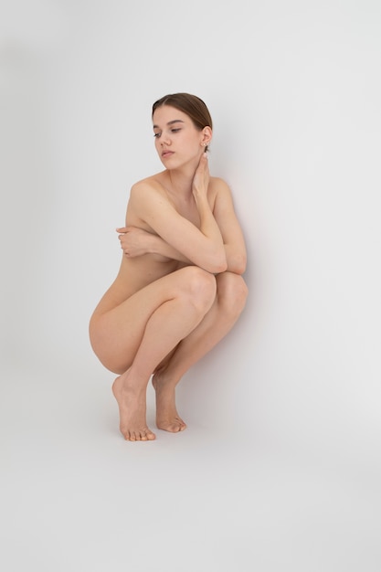 Retrato desnudo de mujer joven de tiro completo