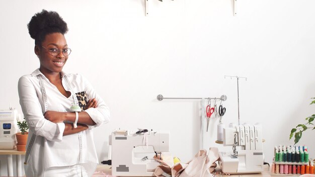 Retrato de un diseñador de moda afroamericano que trabaja en un estudio, sonriente diseñador de moda mira a la cámara