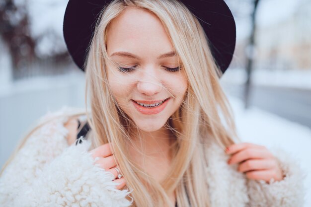 Retrato de divertida chica rubia elegante sonriente con sombrero