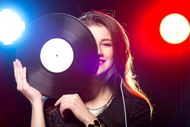 Retrato de la dj femenina con disco de vinilo.