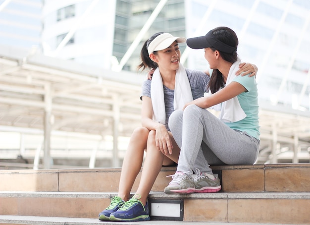 Foto retrato do ajuste e desportivo dois jovem mulher asiática relaxante na cidade.