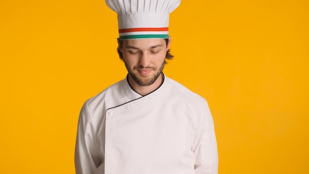 Retrato do chef masculino de uniforme em pé contra um fundo colorido homem atraente pronto para cozinhar comida deliciosa