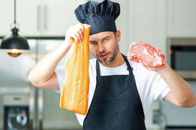 Retrato do chef segurando peixe e carne, salmão e carne bovina em um boné de chef na cozinha, usando abril