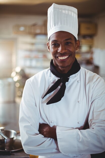 Retrato do chef sorridente em pé com os braços cruzados