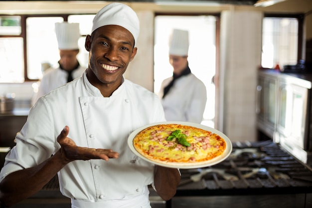 Retrato do chef sorridente mostrando pizza