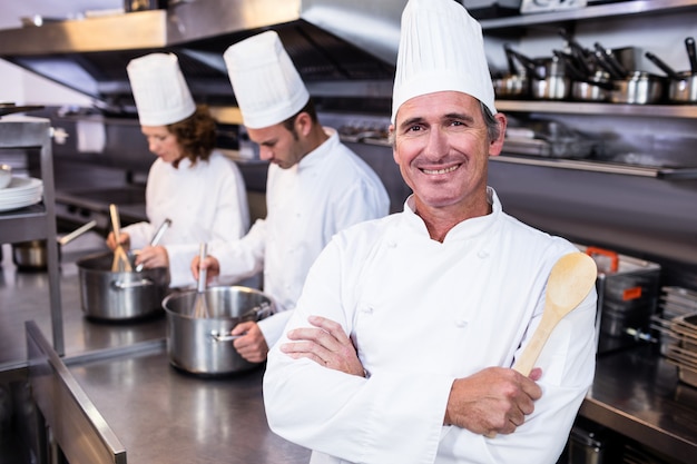 Foto retrato do chef sorridente na cozinha comercial