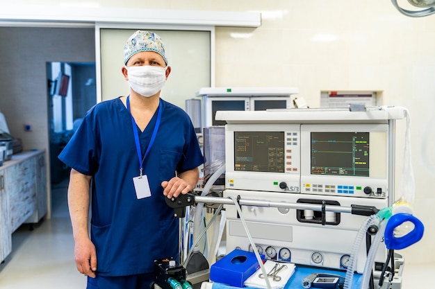 Retrato do cirurgião profissional. Médico usando máscara. Medicamento sentado perto de equipamento profissional.