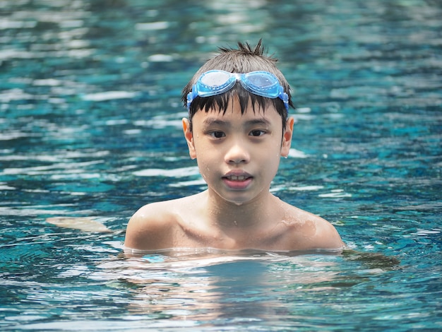 Foto retrato do close-up de garoto bonito na piscina