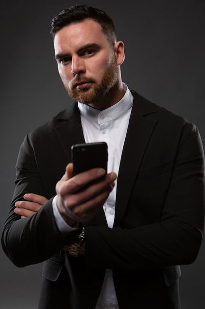 Retrato do close-up de um empresário que verifica as mensagens em seu celular.