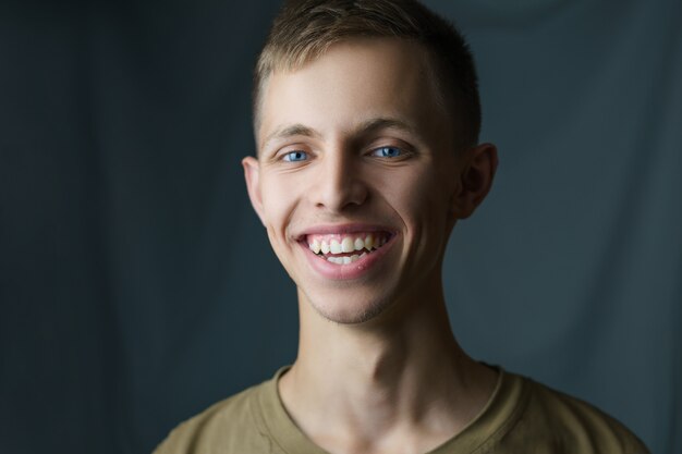 Retrato do close-up de um jovem sorrindo