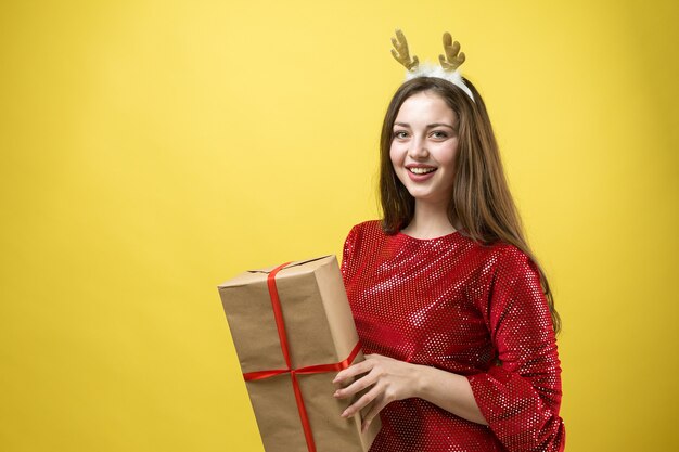 Retrato do close-up de uma menina com presentes nas mãos.