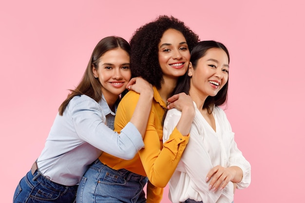 Foto retrato do conceito de amizade de meninas de três mulheres felizes e diversas posando e sorrindo para a câmera