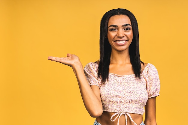 Retrato do conceito de negócios de belos jovens negros afro-americanos apresentando apontando a mão no lado isolado sobre fundo amarelo