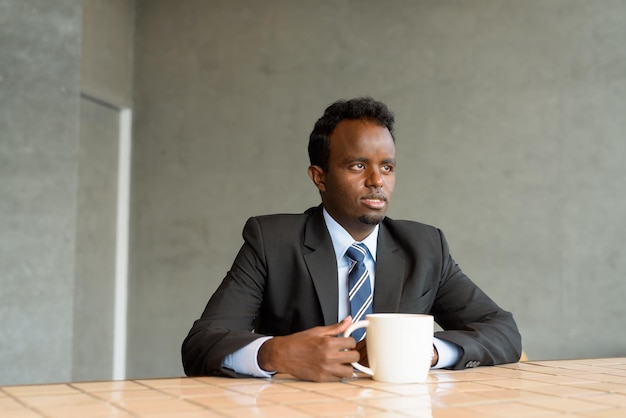 Retrato do empresário africano vestindo terno e gravata no café