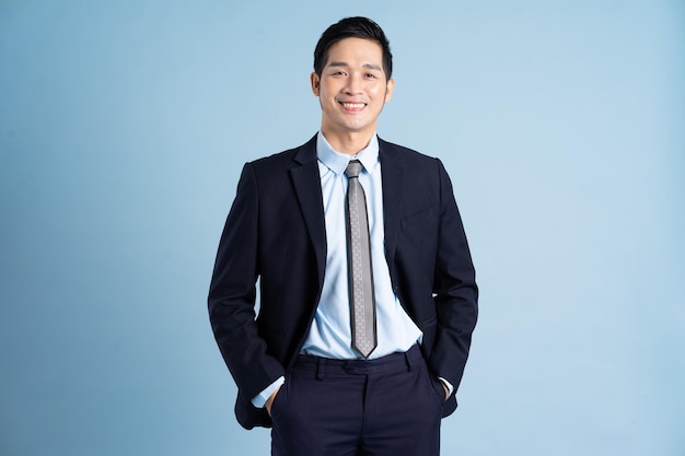 Retrato do empresário asiático vestindo terno no fundo azul