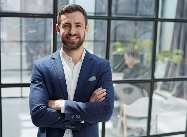 Foto retrato do empresário bem sucedido em pé no escritório de canto