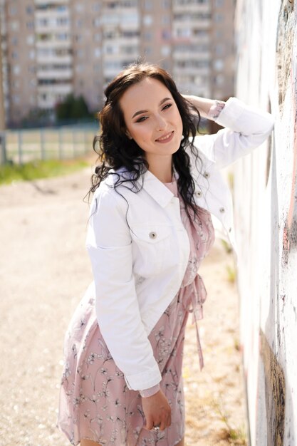 Retrato do estilo de jovem feliz sorridente linda mulher elegante, andando nas ruas da cidade.