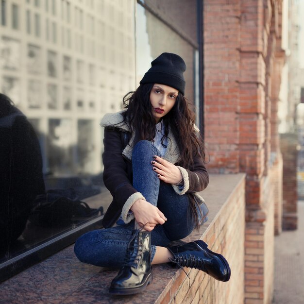 Retrato do estilo de vida ao ar livre de uma jovem bonita vestindo um estilo grunge hipster no meio urbano