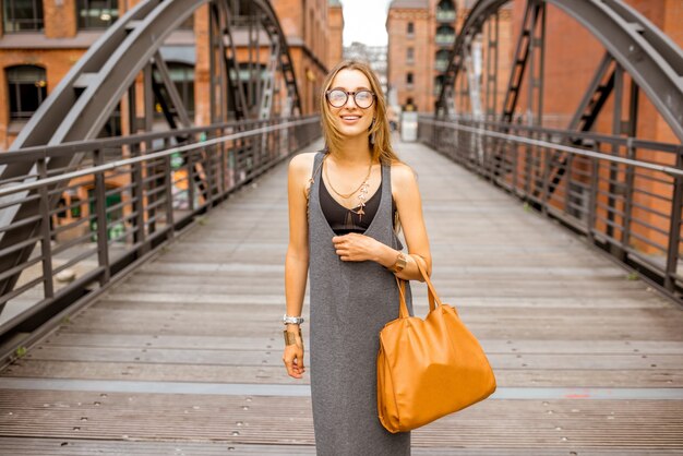 Foto retrato do estilo de vida de uma elegante mulher de negócios caminhando ao ar livre na ponte de ferro em hamburgo, alemanha