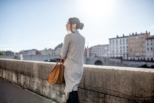 Retrato do estilo de vida de uma elegante mulher de negócios caminhando perto do rio na cidade velha de Lyon durante a manhã na França