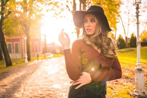 Foto retrato do estilo de vida de uma garota caucasiana com um chapéu em uma floresta andando no outono