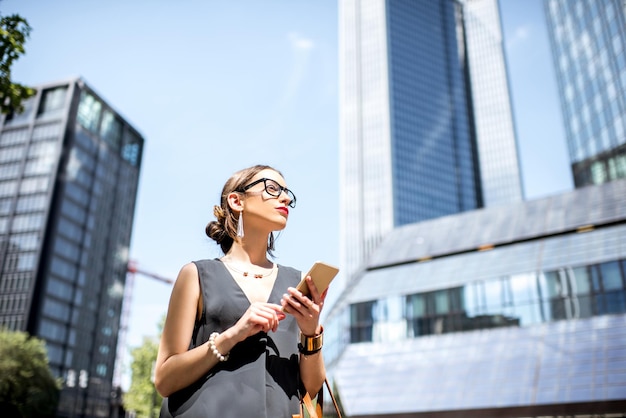 Retrato do estilo de vida de uma mulher de negócios com telefone no bairro moderno da cidade de Frankfurt