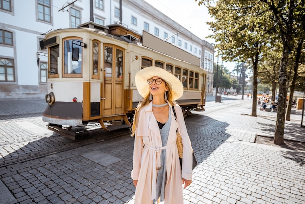 Retrato do estilo de vida de uma mulher perto do famoso velho bonde turístico na rua da cidade do Porto, Portugal