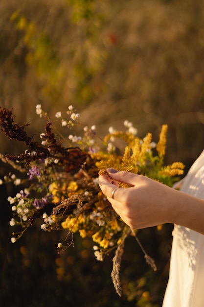 Foto retrato do estilo de vida de verão de uma bela jovem em uma coroa de flores silvestres na cabeça.