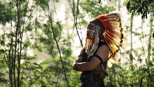 retrato do índio americano em pé contra a floresta.