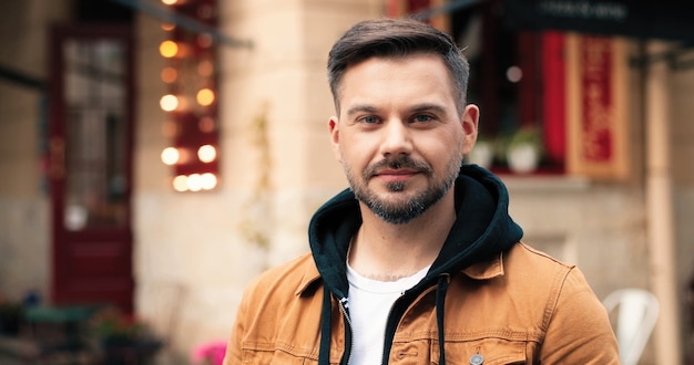 Foto retrato do jovem bonito de etnia caucasiana, com pé de barba na cidade quente de primavera.