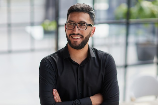 Retrato do jovem empresário sorridente no escritório