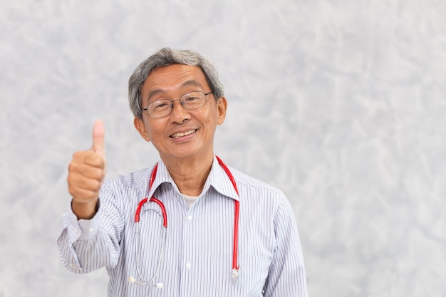 Retrato do médico chinês velho saudável idoso asiático em pé sorriso mão polegares para cima o sinal com espaço para texto.