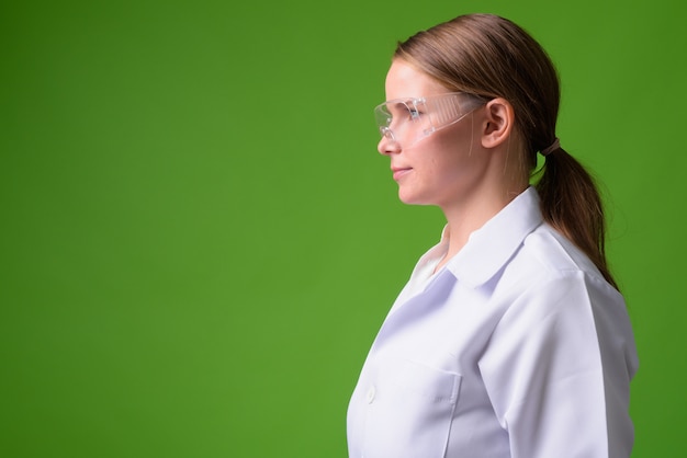 Retrato do médico de uma jovem loira bonita usando óculos de proteção verde