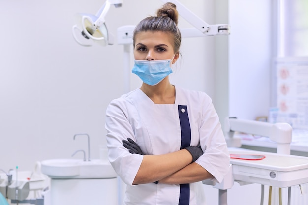 Retrato do médico dentista feminino confiante com braços cruzados